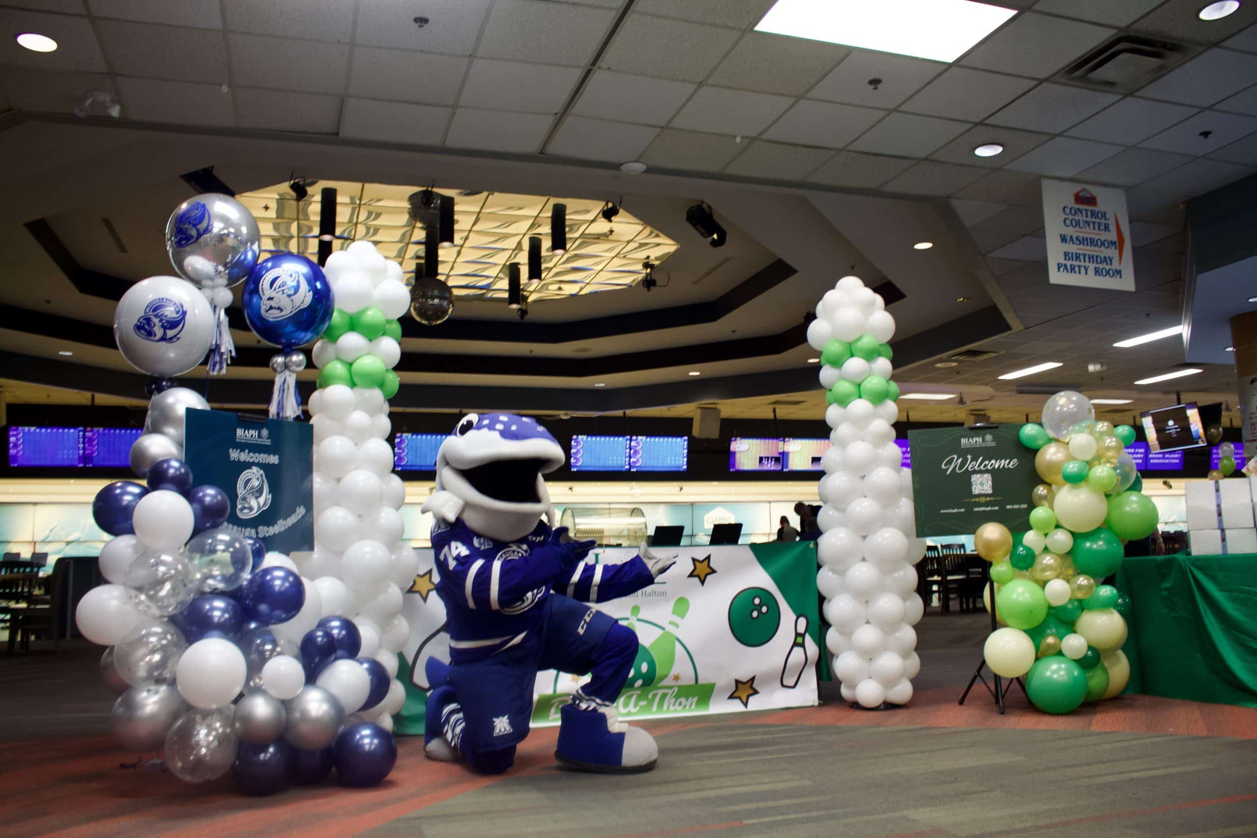 Balloon display for the 17th Annual Bowl-a-thon event. Bowl-a-thon banner in the middle, with two 7 foot balloon bowling pins on opposite side. Two welcome signs on the outer side of the pins. One green sign for BIAPH with green balloons around it, and one blue sign for the Mississauga Steelheads, with blue, white, and silver balloons around it.